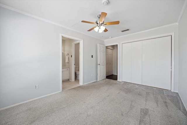 unfurnished bedroom featuring baseboards, visible vents, a closet, carpet floors, and ornamental molding