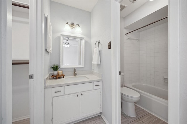 bathroom featuring bathtub / shower combination, toilet, vanity, and a ceiling fan