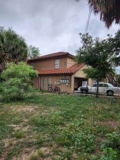 rear view of property featuring stucco siding and a tile roof