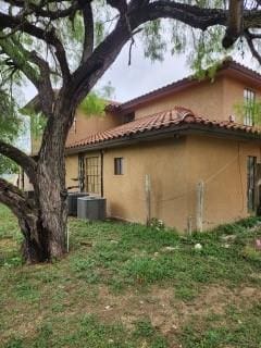 view of property exterior with a tile roof and stucco siding