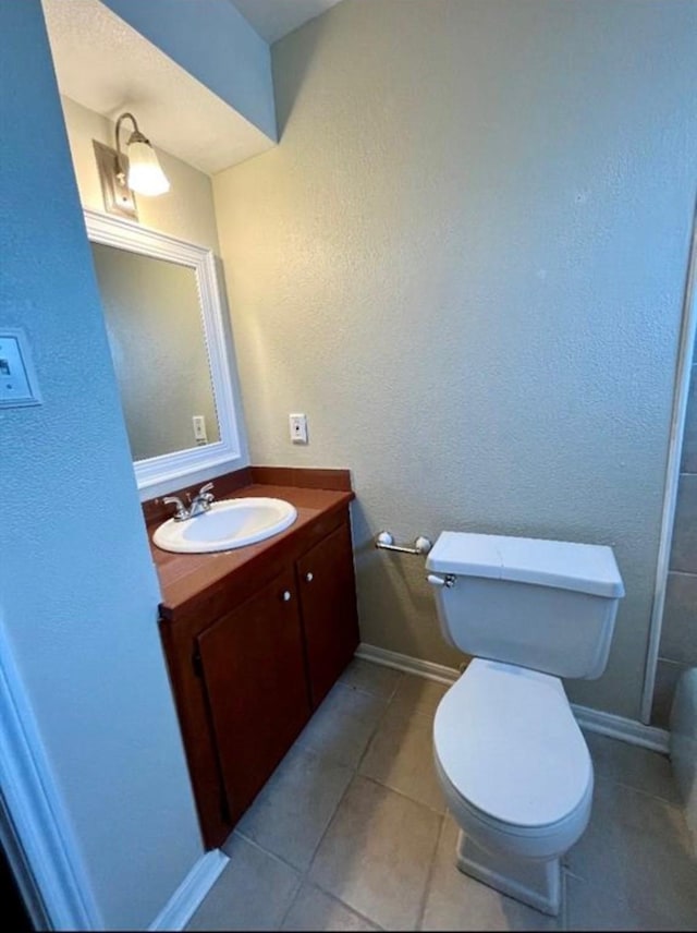 10666 Hazelhurst Dr Unit 22, Houston, TX 77043 - bathroom featuring vanity, toilet, tile patterned flooring, and baseboards