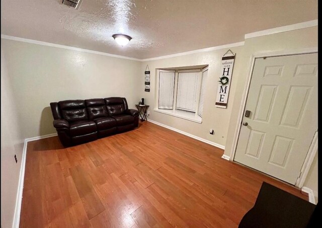 10666 Hazelhurst Dr Unit 22, Houston, TX 77043 - living area with crown molding, wood finished floors, a textured ceiling, baseboards, and visible vents