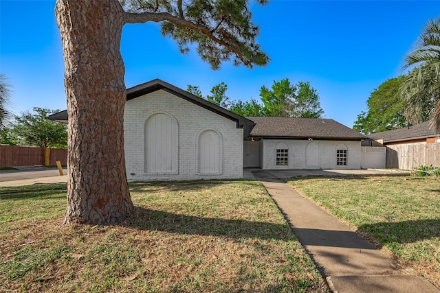 single story home with fence, brick siding, and a front yard