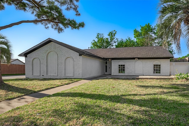 single story home with fence, brick siding, and a front yard