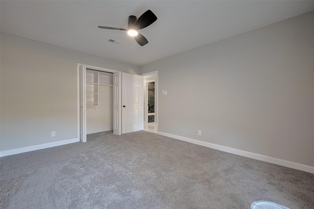 unfurnished bedroom with a closet, ceiling fan, carpet floors, baseboards, and visible vents