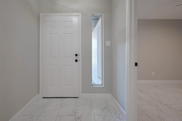 foyer featuring baseboards and marble finish floor