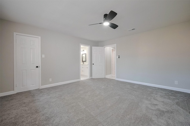 unfurnished bedroom featuring carpet, visible vents, a ceiling fan, connected bathroom, and baseboards