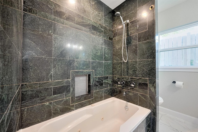 bathroom featuring marble finish floor, baseboards, toilet, and a combined bath / shower with jetted tub