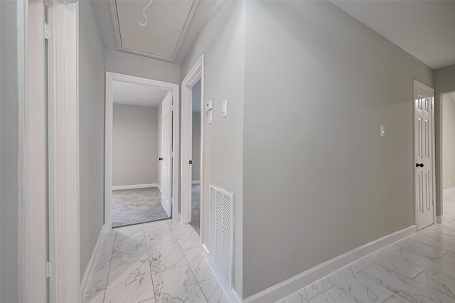 hallway featuring visible vents, marble finish floor, and baseboards