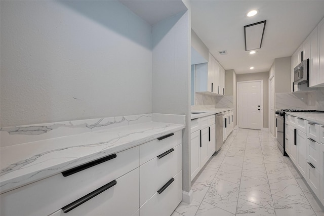 kitchen with white cabinets, stainless steel appliances, marble finish floor, and recessed lighting
