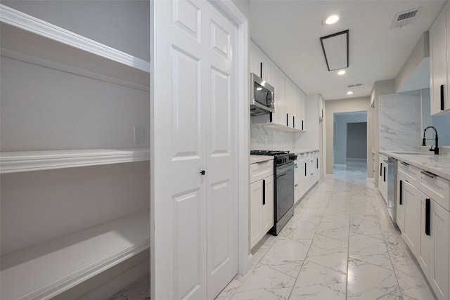 kitchen featuring stainless steel appliances, a sink, visible vents, recessed lighting, and marble finish floor