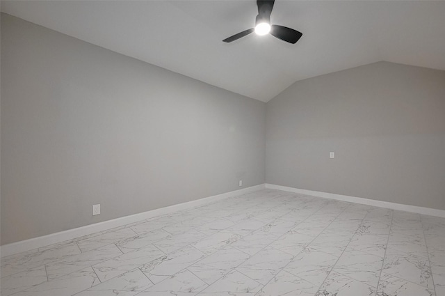empty room featuring lofted ceiling, baseboards, marble finish floor, and ceiling fan