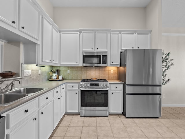 kitchen with white cabinets, stainless steel appliances, light tile patterned floors, a sink, and tasteful backsplash