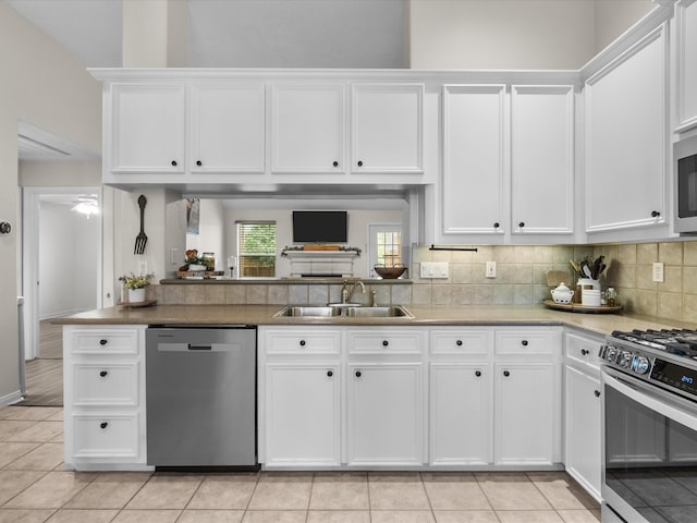 kitchen featuring white cabinets, tasteful backsplash, stainless steel appliances, and a sink
