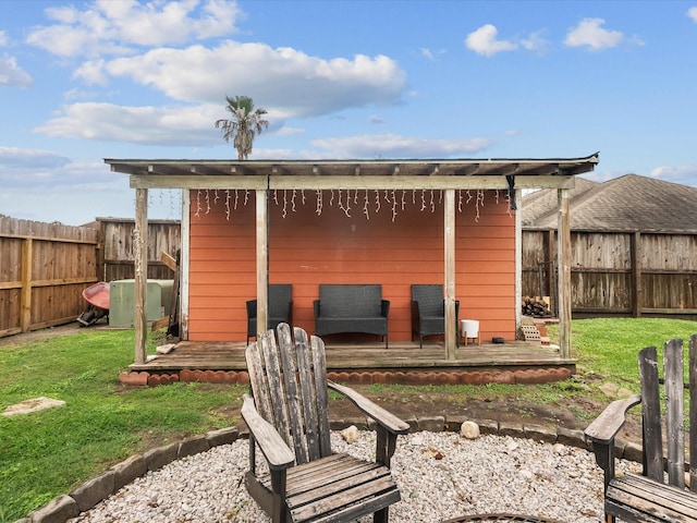 back of house featuring a fenced backyard, a yard, and a deck