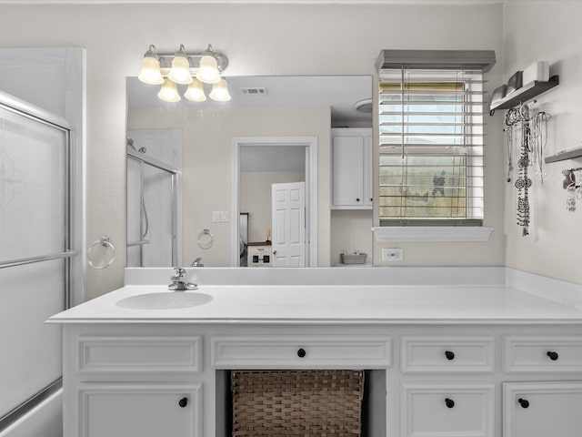 bathroom featuring an enclosed shower, vanity, and visible vents