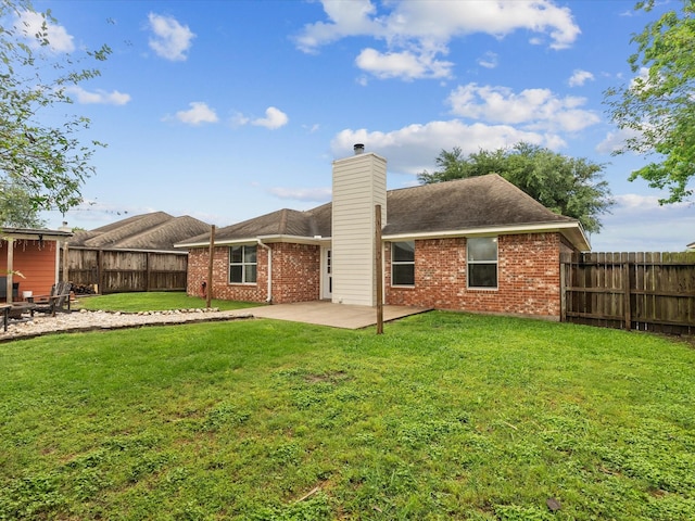 rear view of house featuring brick siding, a patio area, a chimney, and a fenced backyard