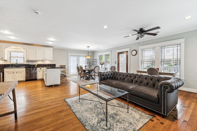 living area with recessed lighting, ornamental molding, light wood-type flooring, and ceiling fan
