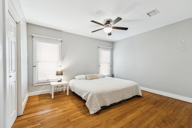 bedroom with ceiling fan, baseboards, visible vents, and light wood-style flooring