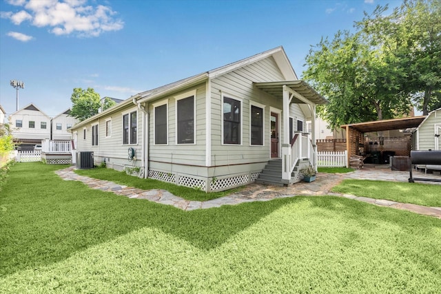 view of front of property featuring crawl space, central AC unit, fence, a front lawn, and a patio