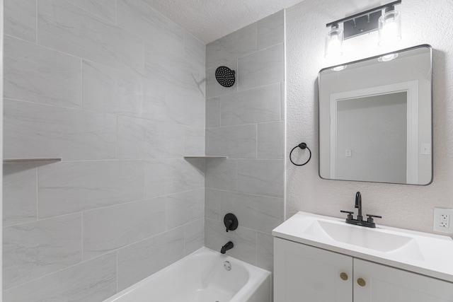 bathroom with a textured wall, washtub / shower combination, a textured ceiling, and vanity
