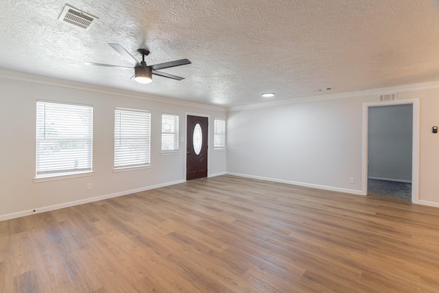foyer featuring crown molding, a textured ceiling, and visible vents