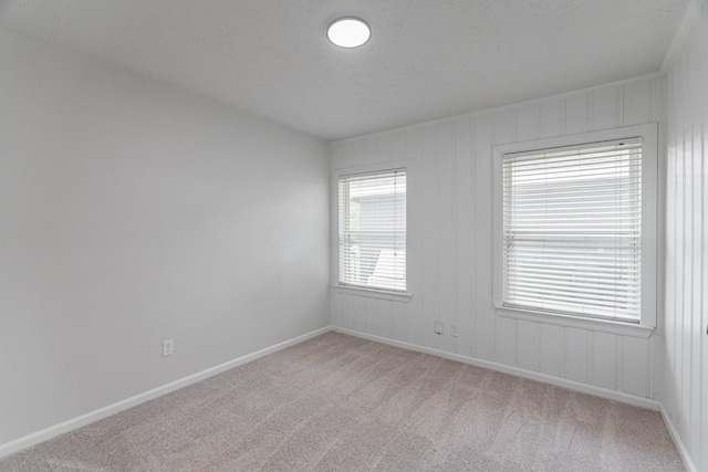 empty room with baseboards and light colored carpet