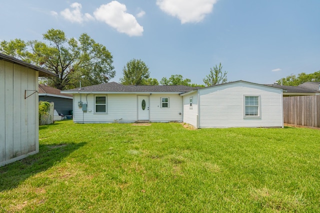 back of property featuring a yard and fence