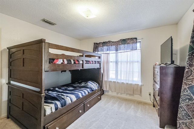 carpeted bedroom with a textured ceiling, visible vents, and baseboards