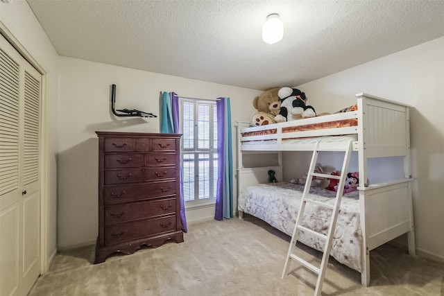 bedroom with carpet flooring, a textured ceiling, and a closet