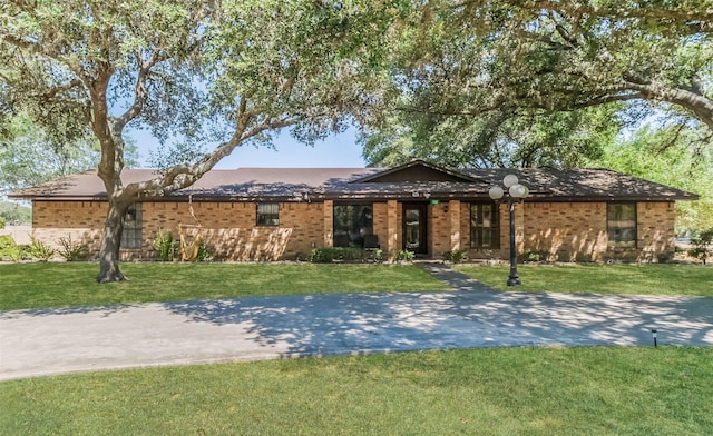 single story home featuring brick siding and a front lawn