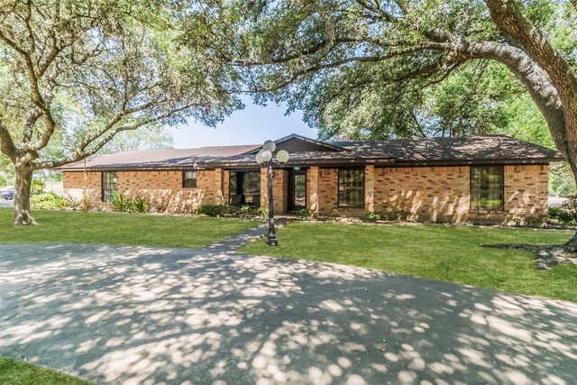 ranch-style home with a front lawn and brick siding