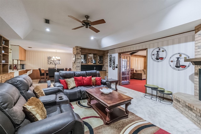 living area featuring lofted ceiling, ceiling fan with notable chandelier, visible vents, and carpet