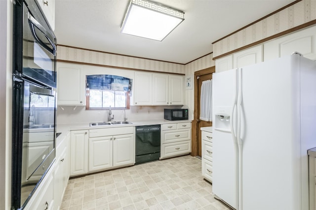kitchen with white cabinets, light floors, light countertops, a sink, and black appliances