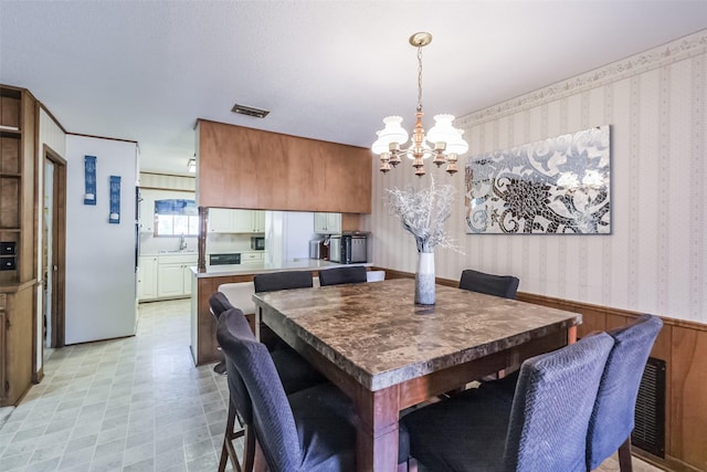 dining room featuring visible vents, a chandelier, and wallpapered walls