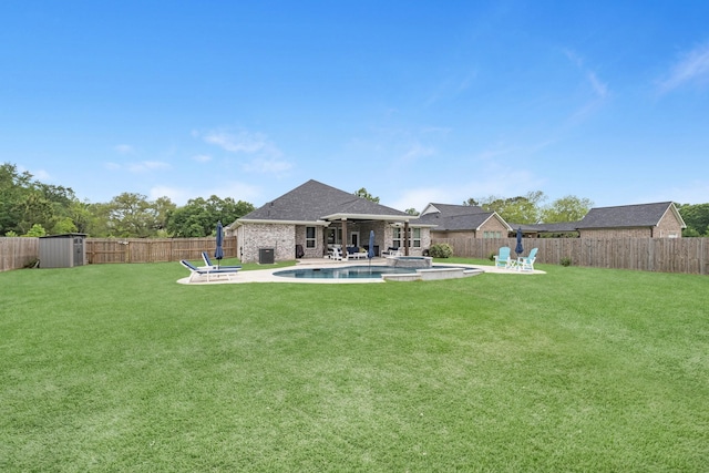 view of yard featuring a fenced backyard, a patio, and an outbuilding