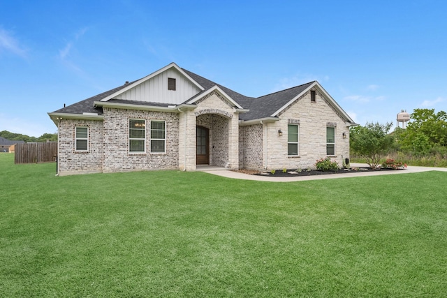 view of front of house featuring fence, board and batten siding, a shingled roof, and a front yard