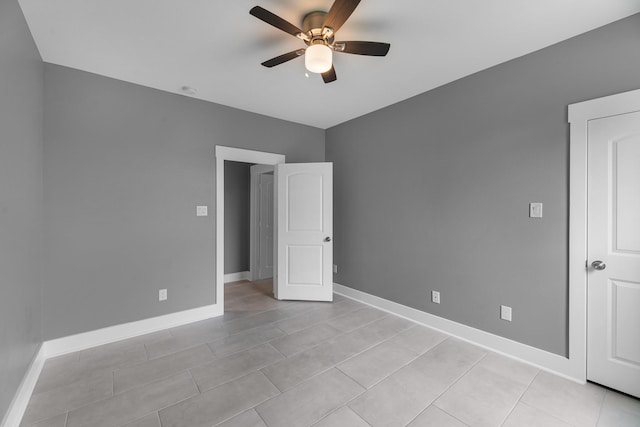 unfurnished bedroom with light tile patterned floors, baseboards, and ceiling fan