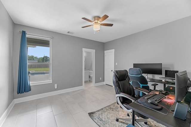 office space featuring light tile patterned flooring, ceiling fan, visible vents, and baseboards