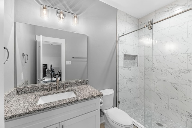 full bathroom featuring toilet, a shower stall, and vanity
