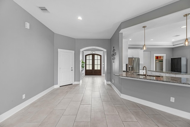 foyer featuring visible vents, arched walkways, baseboards, and recessed lighting