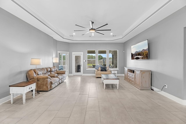 living room featuring ornamental molding, baseboards, ceiling fan, recessed lighting, and a raised ceiling