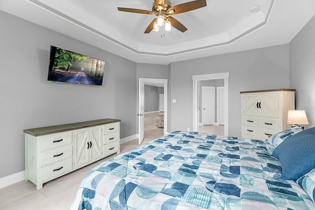 bedroom featuring ornamental molding, baseboards, ceiling fan, a tray ceiling, and light tile patterned floors