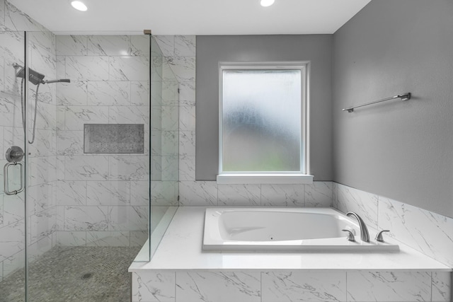 full bath featuring plenty of natural light, a stall shower, recessed lighting, and a garden tub