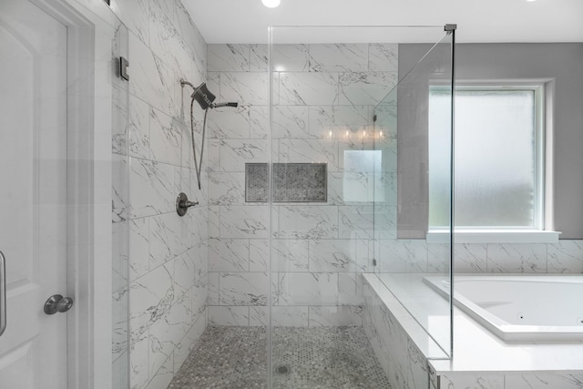 full bath with a bath, a wealth of natural light, and a shower stall