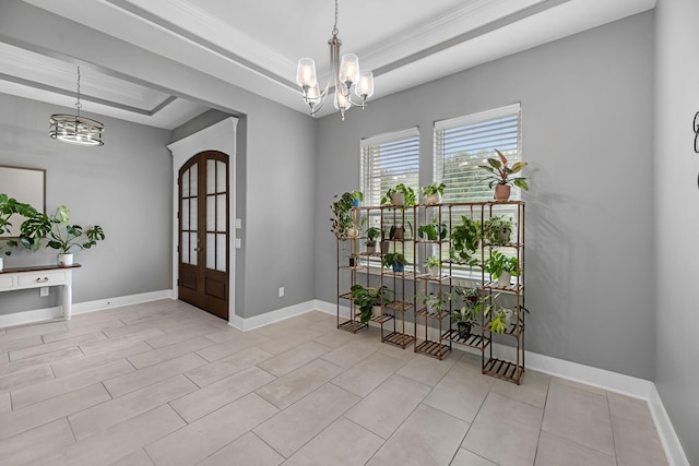 entrance foyer with an inviting chandelier, baseboards, and a tray ceiling
