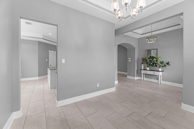 empty room featuring visible vents, arched walkways, baseboards, a chandelier, and a tray ceiling