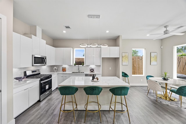 861 Prosper St, Houston, TX 77088 - kitchen featuring a breakfast bar, light wood-style flooring, visible vents, and appliances with stainless steel finishes
