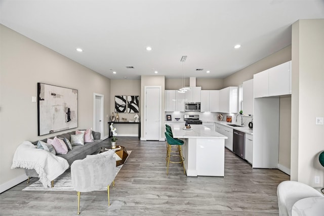 861 Prosper St, Houston, TX 77088 - kitchen with a center island, a sink, stainless steel appliances, light countertops, and white cabinetry