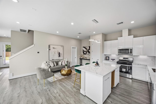861 Prosper St, Houston, TX 77088 - kitchen with a kitchen island, light wood-type flooring, visible vents, and stainless steel appliances